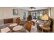 A view of the living area with comfortable seating and a glass table near screened patio doors at 4330 47Th W Ave # 104, Bradenton, FL 34210