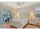 Bright bedroom featuring hardwood floors, a ceiling fan, and sliding door access to the patio at 436 Country Ln, Bradenton, FL 34212