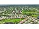 Aerial view of a townhouse community with a pond and mature trees at 4790 Turnberry Cir, North Port, FL 34288