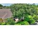 Home with a large shade tree, brick patio, and lush landscaping in the backyard at 4790 Turnberry Cir, North Port, FL 34288