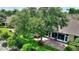 Aerial view of a brick patio extending from a sunroom, shaded by a mature tree in a private backyard setting at 4790 Turnberry Cir, North Port, FL 34288