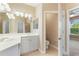 Bright bathroom features a double vanity, a large mirror, and a door leading to the water closet at 4790 Turnberry Cir, North Port, FL 34288