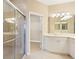 Bathroom features a glass enclosed shower, a vanity with double sinks, and walk-in closet access at 4790 Turnberry Cir, North Port, FL 34288