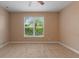 This bedroom offers a neutral carpet, a ceiling fan, and a window with shade at 4790 Turnberry Cir, North Port, FL 34288