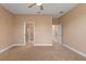 Carpeted bedroom features a ceiling fan and two doorways with white trim and neutral paint at 4790 Turnberry Cir, North Port, FL 34288