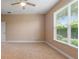 Light and bright carpeted bedroom features a ceiling fan, neutral walls, and a large window at 4790 Turnberry Cir, North Port, FL 34288