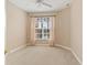 Bright, carpeted bedroom featuring a ceiling fan, a large window with blinds and a neutral color palette at 4790 Turnberry Cir, North Port, FL 34288