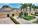 Exterior view of home with a beautiful brick driveway, manicured landscaping, and palm trees at 4790 Turnberry Cir, North Port, FL 34288