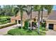 Exterior view of home with a brick driveway, manicured landscaping, and mature palm trees at 4790 Turnberry Cir, North Port, FL 34288