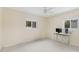 Bedroom with neutral walls, two windows providing natural light, ceiling fan, and computer desk at 507 59Th St, Holmes Beach, FL 34217
