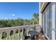 Relax on the balcony with black wrought iron table and seating overlooking lush greenery at 5420 Eagles Point Cir # 106, Sarasota, FL 34231