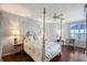 Main bedroom with hardwood floors, floral-themed linens and ceiling fan at 5420 Eagles Point Cir # 106, Sarasota, FL 34231