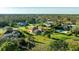 Overhead view of single Gathering home with lush, mature trees, a screened in lanai, and other well-maintained homes nearby at 6107 Glen Abbey Ln, Bradenton, FL 34202