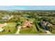 Stunning aerial view of the house with a large yard, mature trees, a pond and picturesque golf course views at 6107 Glen Abbey Ln, Bradenton, FL 34202