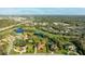 Wide aerial view showing the neighborhood, bodies of water, with lots of mature trees in a well-manicured golf course community at 6107 Glen Abbey Ln, Bradenton, FL 34202