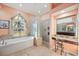 Elegant bathroom featuring a soaking tub, vanity area, and a glass block shower wall at 6107 Glen Abbey Ln, Bradenton, FL 34202