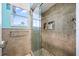 Nicely tiled bathroom with a glass shower enclosure, a window, and built-in shelving at 6107 Glen Abbey Ln, Bradenton, FL 34202
