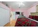 Bedroom featuring pink walls, hardwood floors, closet, TV and a decorative bedspread at 6107 Glen Abbey Ln, Bradenton, FL 34202