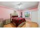 Cozy bedroom with pink walls, a decorative bedspread, window seat, and a bright window at 6107 Glen Abbey Ln, Bradenton, FL 34202