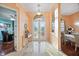 Elegant foyer featuring marble floors, decorative glass doors, and views into the dining and office areas at 6107 Glen Abbey Ln, Bradenton, FL 34202