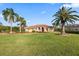 Home's facade surrounded by lush landscaping and mature palm trees at 6107 Glen Abbey Ln, Bradenton, FL 34202