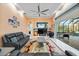 Spacious living room with large windows, leather sofas, a ceiling fan, and access to the pool area at 6107 Glen Abbey Ln, Bradenton, FL 34202