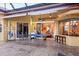 This covered patio area offers an outdoor pool table and seamless indoor-outdoor transition at 6107 Glen Abbey Ln, Bradenton, FL 34202