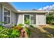 Backyard featuring a sliding glass door, green grass, tropical plants, and blue skies at 6929 Arbor Oaks Cir, Bradenton, FL 34209