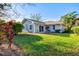 View of the green backyard with a well-maintained lawn, mature landscaping, and a charming home at 6929 Arbor Oaks Cir, Bradenton, FL 34209