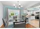 Dining area featuring a glass table, modern chandelier and view into the kitchen at 6929 Arbor Oaks Cir, Bradenton, FL 34209