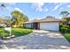 Charming home featuring a well-manicured lawn, mature trees, and a two-car garage at 6929 Arbor Oaks Cir, Bradenton, FL 34209