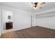 Bright bedroom with hardwood floors, ceiling fan, large closet, and an adjacent bathroom at 7018 13Th E Ave, Bradenton, FL 34208