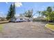 Exterior shot of home, gravel driveway, and neatly landscaped front yard, including a large lawn at 7018 13Th E Ave, Bradenton, FL 34208