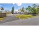 Landscaped home exterior featuring a gravel driveway, green lawn and gated entrance at 7018 13Th E Ave, Bradenton, FL 34208