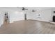 Spacious living room featuring wood-look floors, ceiling fans, and bright white walls at 7018 13Th E Ave, Bradenton, FL 34208