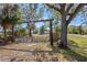 Gated property entrance with mature trees and a view of the home in the distance at 7018 13Th E Ave, Bradenton, FL 34208