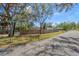 Street view of home exterior with fenced yard and mature trees at 7018 13Th E Ave, Bradenton, FL 34208