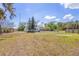 Large vacant grassy lot, ready for new construction, surrounded by mature trees and fencing at 7018 13Th E Ave, Bradenton, FL 34208