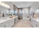 Elegant bathroom with a glass enclosed shower, soaking tub, and dual vanities at 7928 Redonda Loop, Bradenton, FL 34202