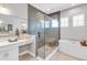 Glass-enclosed shower and soaking tub in a bright, modern primary bathroom at 7928 Redonda Loop, Bradenton, FL 34202