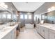 Bright bathroom featuring double vanities, a soaking tub, and a glass-enclosed shower with elegant fixtures at 7928 Redonda Loop, Bradenton, FL 34202