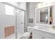 Bright bathroom featuring a tiled shower with glass door, white vanity, and stylish decor at 7928 Redonda Loop, Bradenton, FL 34202