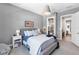 Comfortable bedroom with soft gray walls, a stylish bed, and a view into the bathroom at 7928 Redonda Loop, Bradenton, FL 34202
