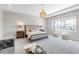 Bright, neutral bedroom with tufted headboard, chandelier, and plenty of natural light at 7928 Redonda Loop, Bradenton, FL 34202