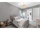 Cozy bedroom featuring a tufted headboard, chandelier, and ensuite bathroom for added privacy at 7928 Redonda Loop, Bradenton, FL 34202