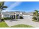 Beautiful home exterior featuring a well-maintained lawn, lush landscaping and a three car garage at 7928 Redonda Loop, Bradenton, FL 34202