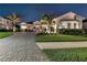 Beautifully landscaped home featuring a paver driveway, mature landscaping, and a well-lit exterior at 7928 Redonda Loop, Bradenton, FL 34202
