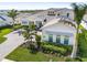 Exterior elevation of a luxurious home with a paver driveway, lush landscaping, and a well-manicured lawn at 7928 Redonda Loop, Bradenton, FL 34202