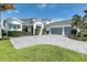 Elegant home exterior featuring a spacious driveway, a well-manicured lawn, and mature landscaping at 7928 Redonda Loop, Bradenton, FL 34202
