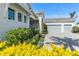 Two car garage with gray doors and manicured shrubs and flowering plants in front at 7928 Redonda Loop, Bradenton, FL 34202